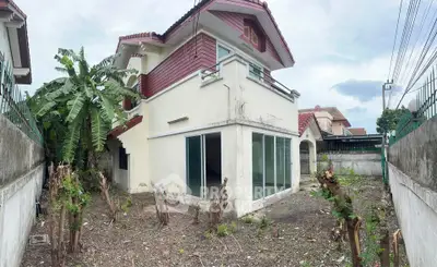 Charming two-story house with spacious garden and modern sliding glass doors, perfect for family living.