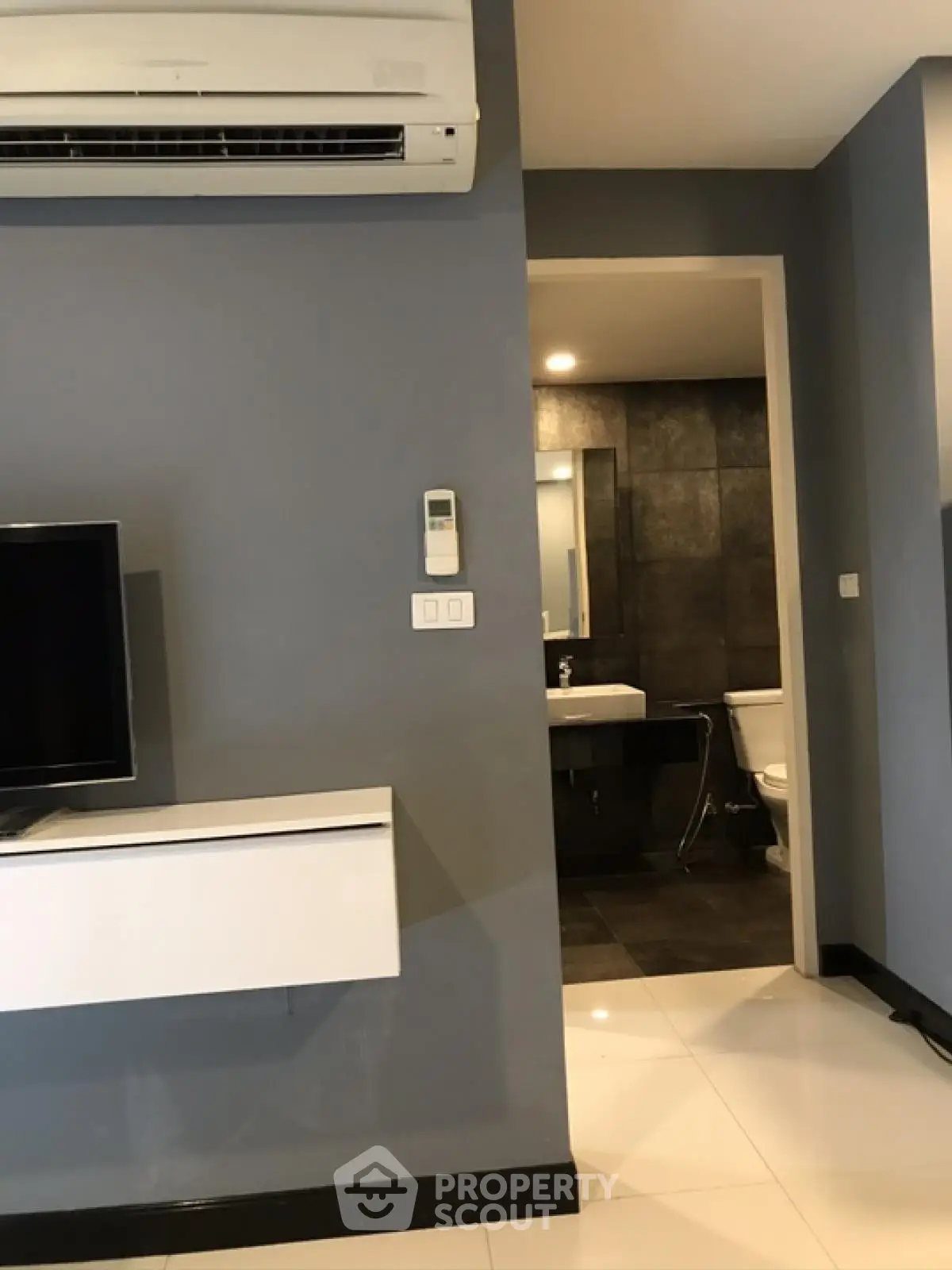 Modern apartment interior with sleek design featuring air conditioning and a glimpse of the bathroom.