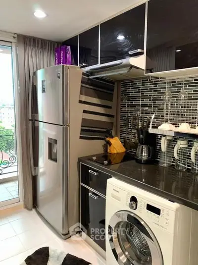 Modern kitchen with stainless steel appliances and sleek cabinetry, featuring a washing machine and balcony view.