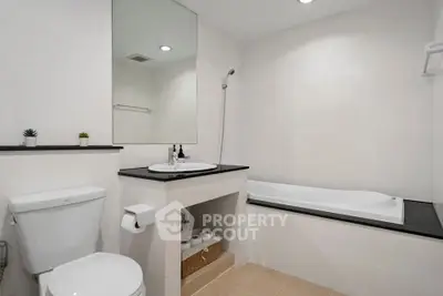 Modern bathroom with sleek design, featuring a bathtub and elegant fixtures.