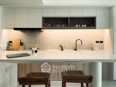 Modern kitchen with sleek cabinetry and stylish bar stools in a contemporary home.