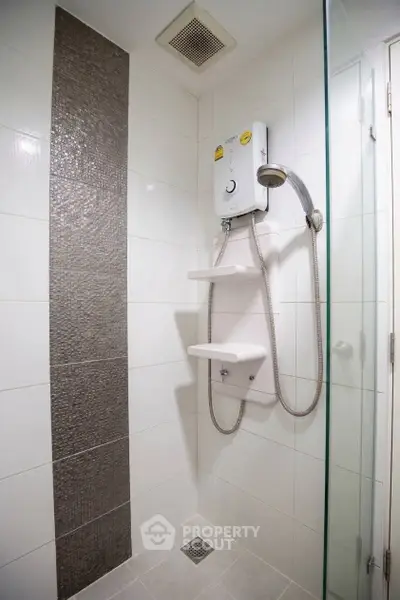 Modern bathroom shower area with sleek design and efficient water heater.