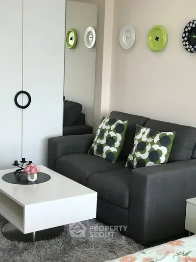 Stylish modern living room with cozy gray sofa and chic decor accents.