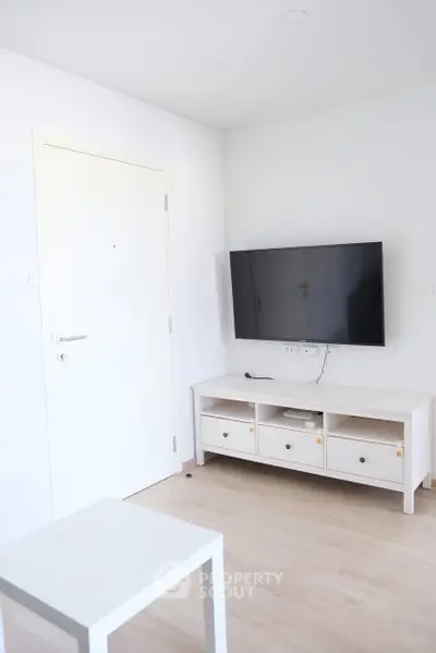 Modern minimalist living room with wall-mounted TV and white furniture