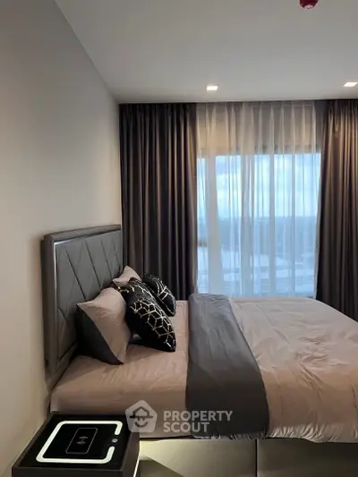 Luxurious bedroom with elegant decor and large window offering natural light.