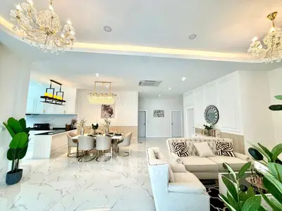 Luxurious open-plan living and dining area with elegant chandeliers and modern decor.