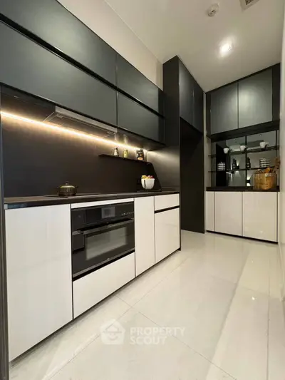 Sleek modern kitchen with black and white cabinetry and built-in appliances