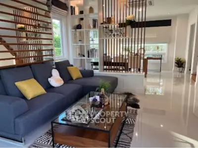 Spacious modern living room with elegant decor and open layout, featuring a stylish sofa and glass coffee table.