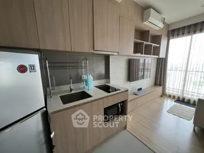 Modern kitchen with sleek wooden cabinetry and integrated appliances in a stylish apartment.