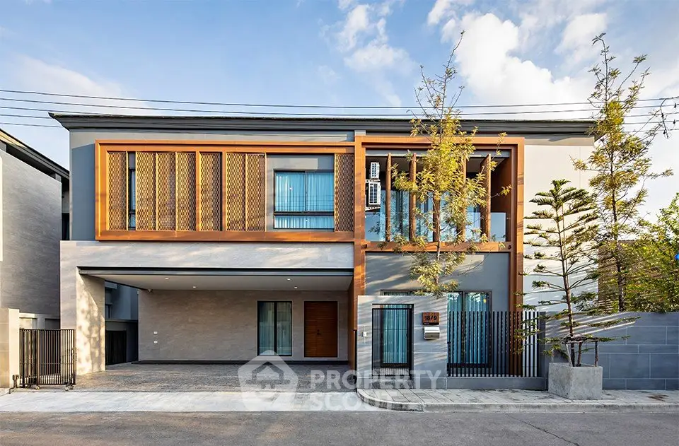 Modern two-story house with sleek design and large windows, featuring a spacious driveway and contemporary landscaping.
