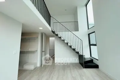 Modern duplex interior with sleek staircase and large windows