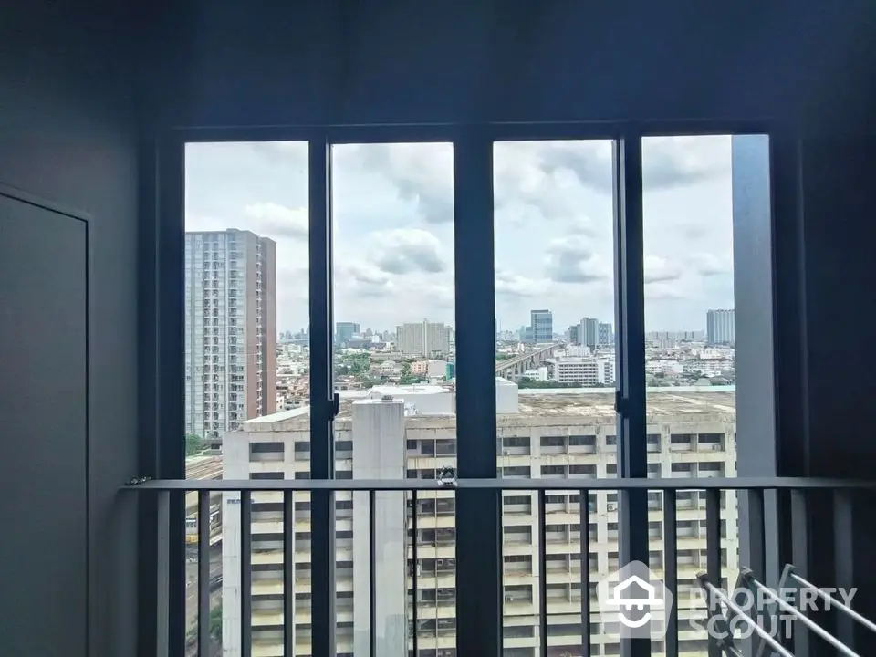 Stunning cityscape view from modern apartment balcony with expansive windows.