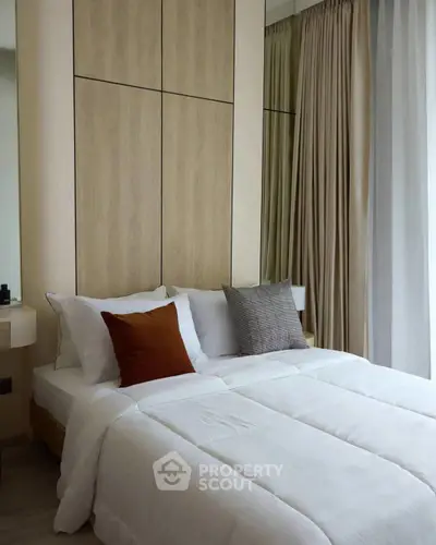 Modern bedroom with stylish decor and cozy bedding in a contemporary apartment.