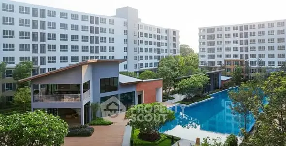 Modern apartment complex with lush greenery and a large swimming pool, offering a serene living environment.