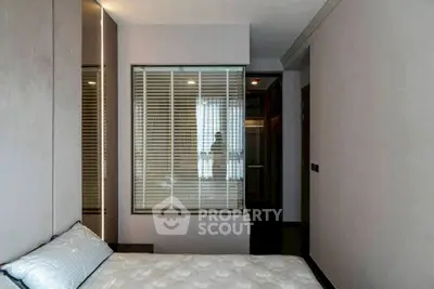 Modern bedroom with sleek design and large window for natural light.