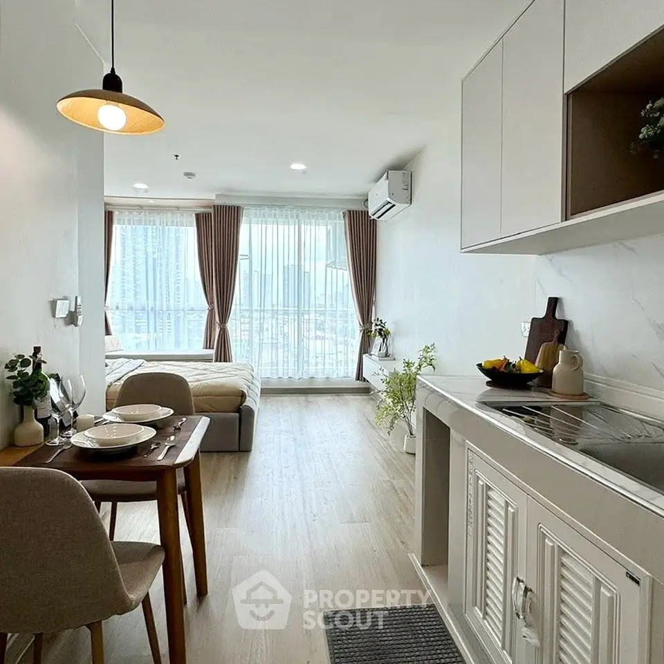 Modern studio apartment with open layout, featuring a cozy dining area and a bright, airy atmosphere.