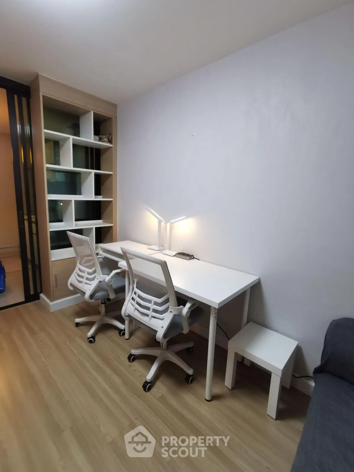Modern study room with sleek white desk and chairs, perfect for productivity.