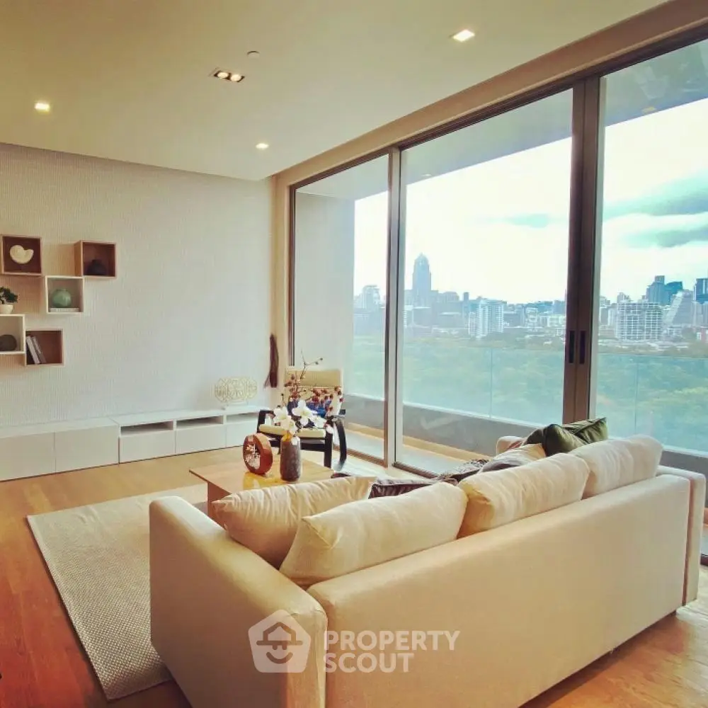 Spacious living room with large windows offering stunning city views, modern decor, and cozy seating area.