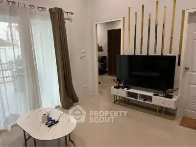 Modern living room with stylish decor and large TV, featuring elegant curtains and a marble coffee table.