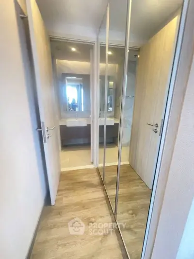 Modern bathroom with mirrored closet doors and dual sinks in a stylish apartment.