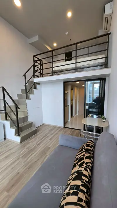 Modern loft apartment with mezzanine, stylish staircase, and cozy living area.