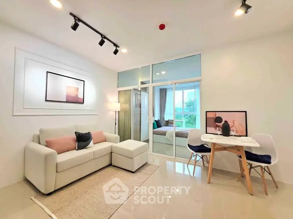 Modern living room with cozy seating and dining area, featuring elegant decor and natural light.