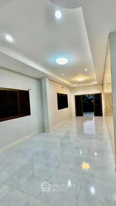 Spacious modern living room with elegant lighting and large windows, perfect for family gatherings.