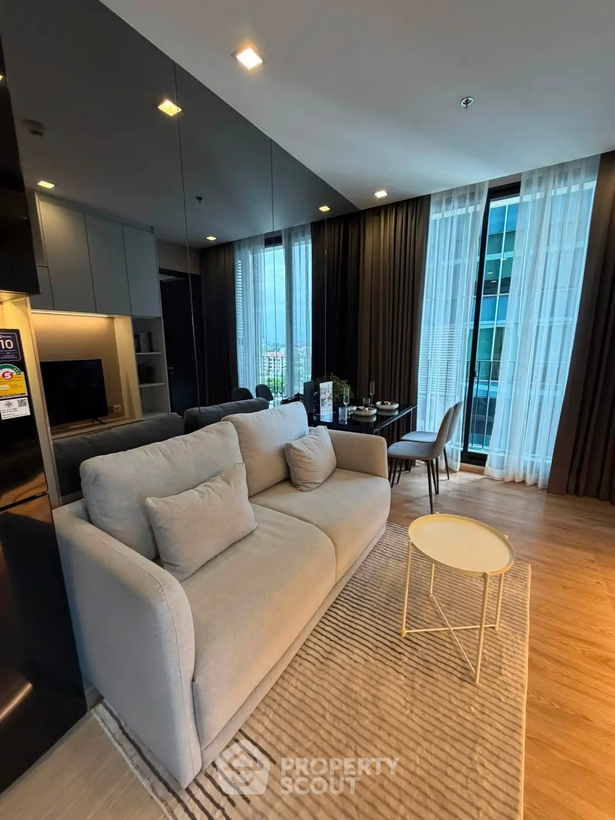 Modern living room with elegant decor and floor-to-ceiling windows in a high-rise apartment.