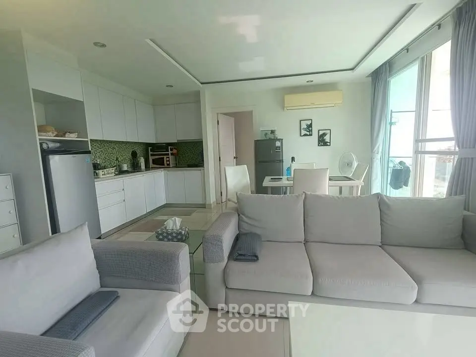 Spacious modern living room with open kitchen and large windows in a stylish apartment.