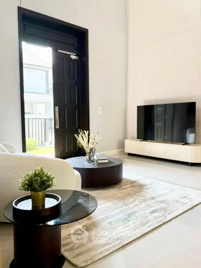 Modern living room with stylish furniture and large TV, bright and inviting space.