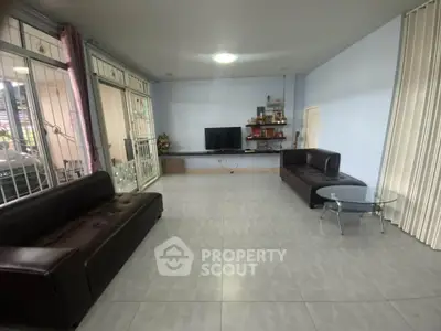 Spacious living room with modern sofas and large TV, perfect for family gatherings.