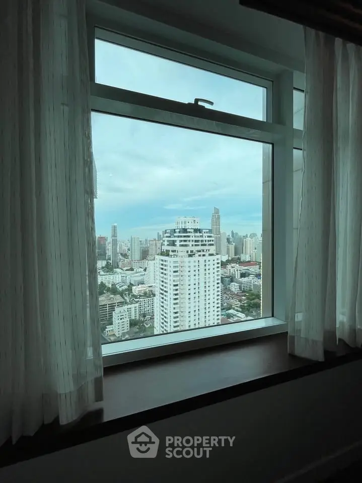 Stunning cityscape view from a high-rise window, showcasing urban skyline and modern architecture.
