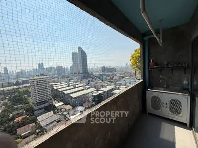 Stunning city view from a high-rise balcony with a small kitchenette.