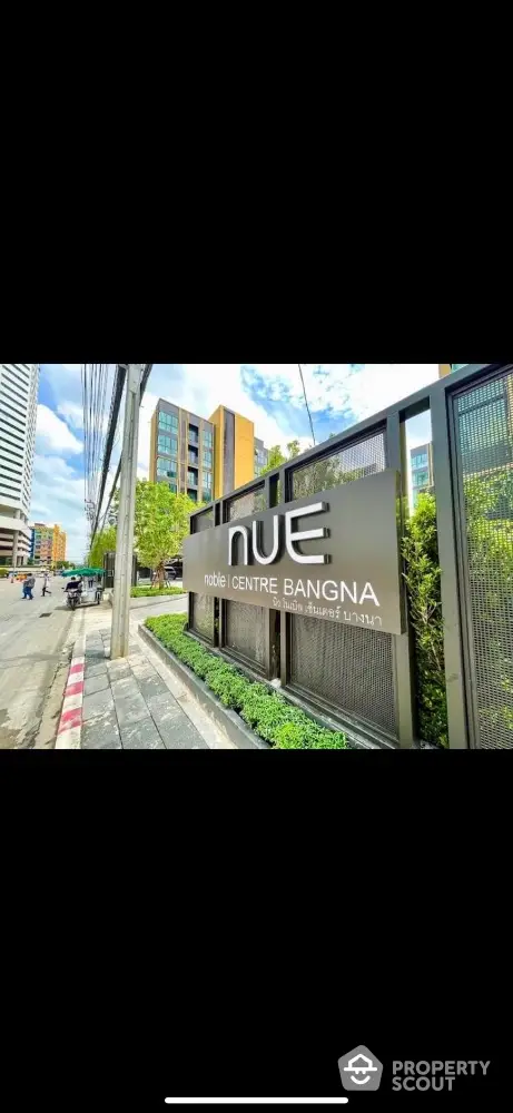 Modern urban building entrance with signage at Nue Centre Bangna, showcasing contemporary architecture.