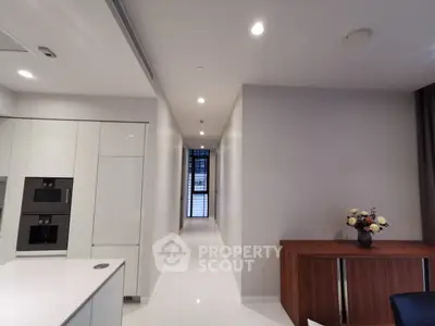 Modern kitchen with sleek appliances and elegant hallway in luxury apartment