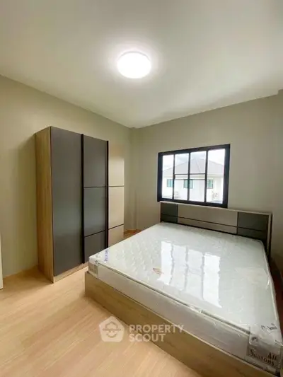 Modern bedroom with natural light and stylish furniture in a cozy apartment.