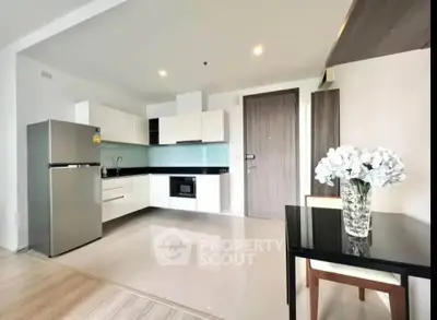 Modern kitchen with sleek appliances and dining area in stylish apartment