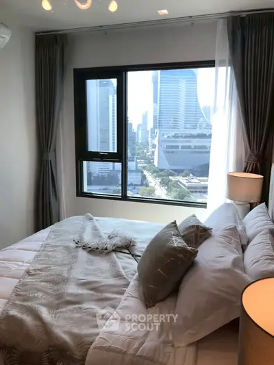 Cozy bedroom with city view, featuring elegant decor and ample natural light.