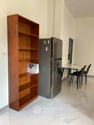Modern kitchen with sleek fridge and dining area in open layout