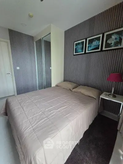 Cozy bedroom with modern decor and stylish wall art, featuring a comfortable bed and mirrored wardrobe.