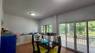 Spacious kitchen with dining area and garden view, featuring modern appliances and ample natural light.