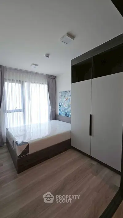 Modern bedroom with large window and stylish wardrobe in a bright apartment