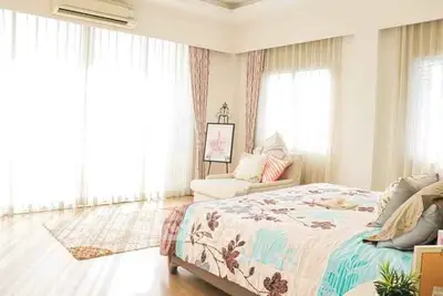Spacious and bright bedroom with elegant decor and large windows.