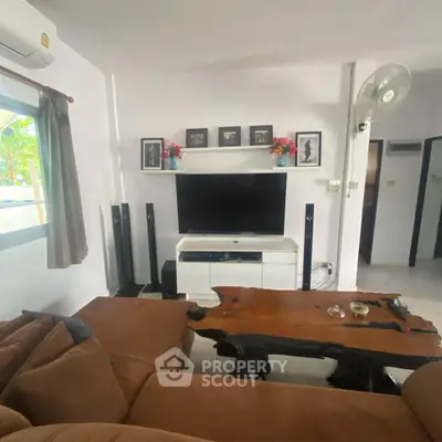 Cozy living room with rustic wooden coffee table and modern entertainment setup.