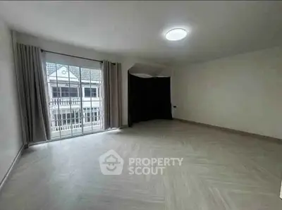 Spacious empty room with large window and elegant flooring