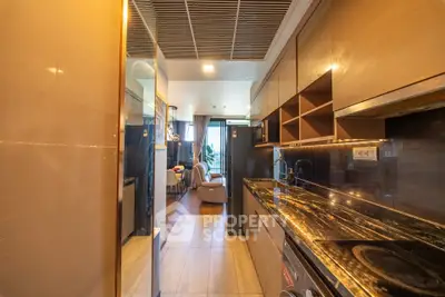 Luxurious modern kitchen with sleek design and open layout leading to a stylish living area.