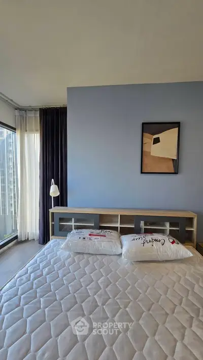 Modern bedroom with large windows and stylish decor in a high-rise apartment.