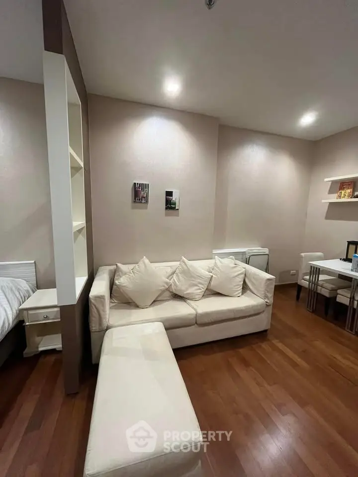 Modern living room with cozy white sofa and wooden flooring in stylish apartment.