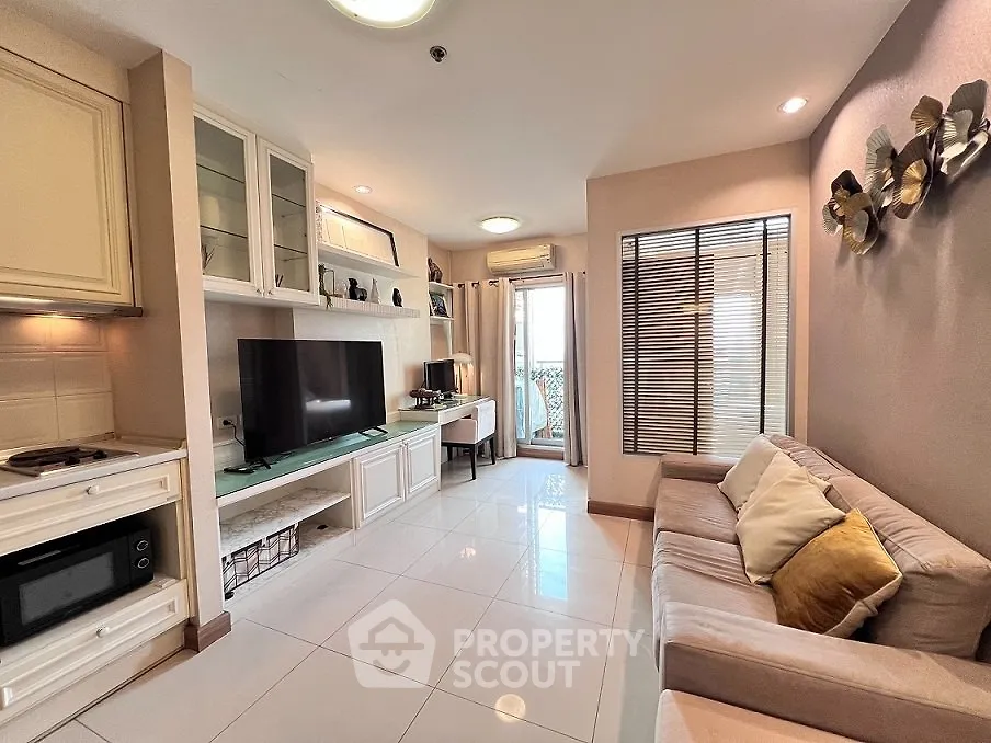Stylish living room with modern decor, large TV, and cozy seating area, perfect for relaxation.