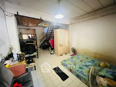 Cozy bedroom with minimalist decor and loft-style layout, featuring a bed, wardrobe, and staircase.